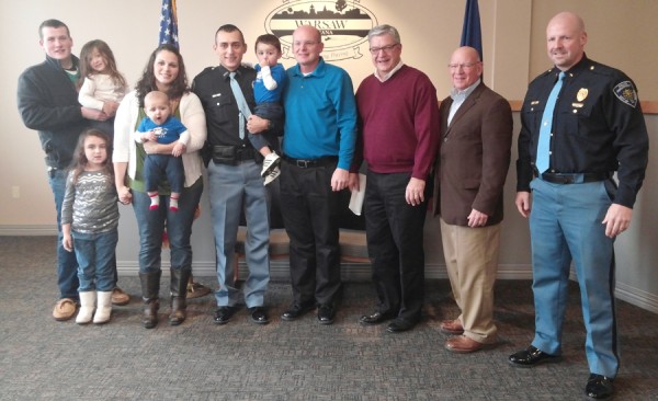 Present for the swearing in ceremony of Officer Phil Hawks were his brother, Landon Hawks; holding Officer Hawks daughter Abby; daughter Olivia, wife Becky, holding Owen; Officer Hawks holding son Gabriel, Jeff Grose, board member; Mayor Joe Thallemer; Charles Smith, board member; and Warsaw Fire Chief Scott Whitaker. (Photo by Deb Patterson)