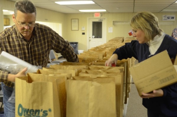 Charlie Albertson and Kristy Hooker were two of about a dozen members of United Steel Workers Local 809 members bagging over 280 Christmas dinners to hand out this morning. (Photo by Deb Patterson)