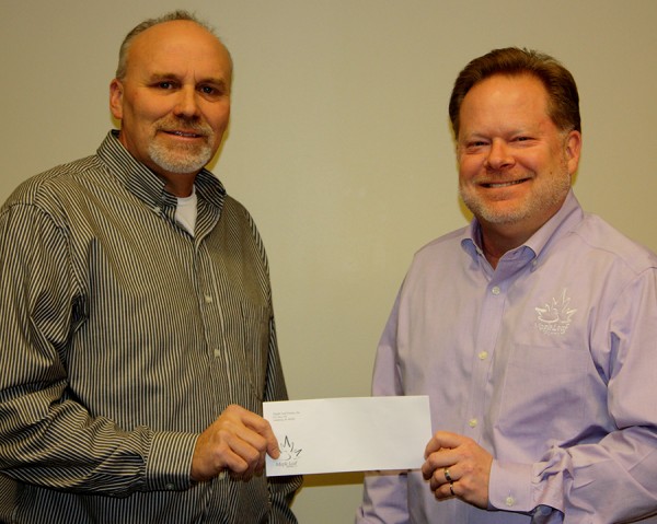 Leesburg Lions Club President Scott Kammerer accepts the donation from Maple Leaf Farms Co-President Scott Tucker.  