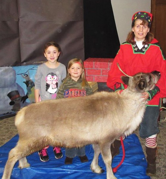 Paige Fuller and Audra Weaver pose with Olaf the Reindeer and "Artic Angie" at Reindeer at the Library event.