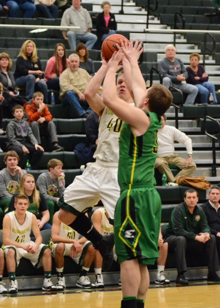 Alex Clark hits a mid-range jumper despite tight defense from an Eastside player.