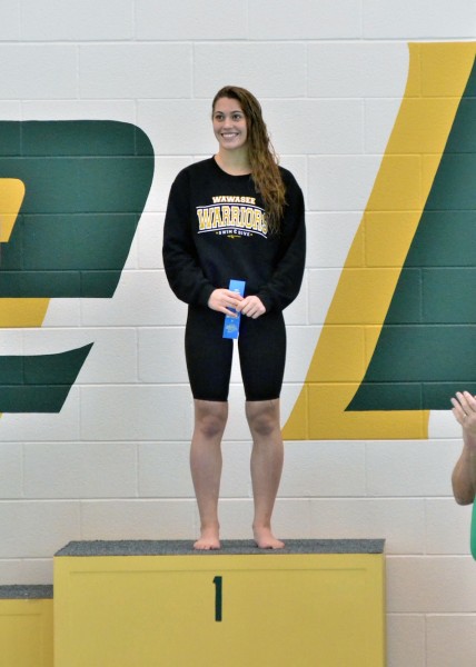 Bre Robinson is all smiles while taking the podium following her sectional win in the 100 fly. (Photo by Nick Goralczyk)