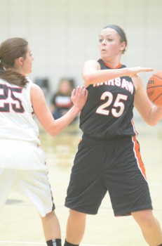 Madi Graham of Warsaw protects the ball from the defense of Gabi Glass Saturday night.