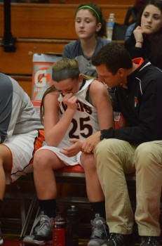 Madi Graham is attended to by trainer Corey Branam on the Warsaw bench Friday night.