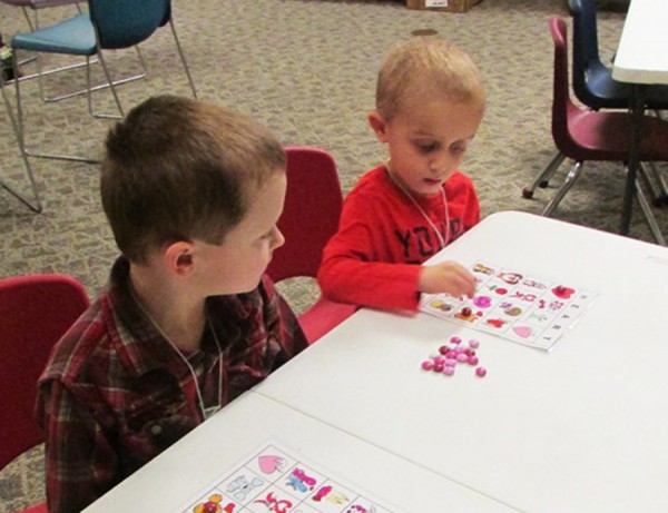 Westen Haab and Owen Morehouse focus intently as they play February Bingo for Valentines Story Time. Kids used Valentine M&M’s as their bingo markers. 