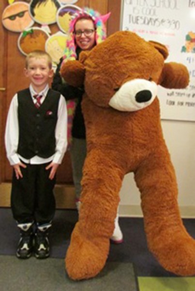 Isaiah Charles stands with his mom, Mandy Kennedy, and his new five foot tall Teddy Bear. Isaiah was the winner of our drawing for the Teddy Bear that took place during the month of February in the children’s department.