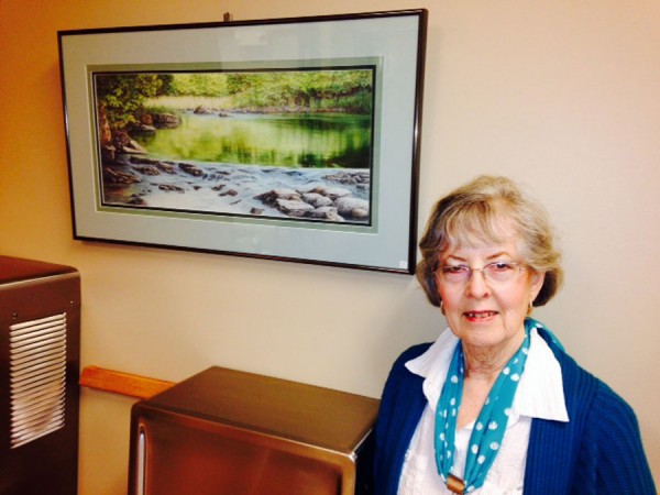 Bev Garner with one of her winning colored pencil works currently on exhibit at Warsaw City Hall.