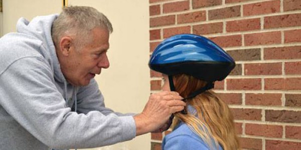 Dick Pellitier adjusts a helmet on a participant,