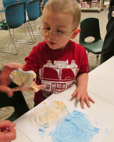 Jake Karrick enjoys painting with his puffy paint made out of shaving cream, glue, an tempera paint during Spring Story Time. 
