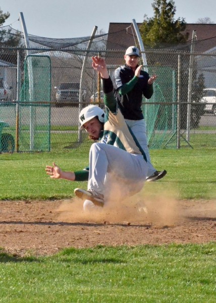 Wawasee head coach Brent Doty (back) claps as Nate Prescott slides into home for the Warriors during Tuesday's 8-7 win over Whitko. (Photos by Nick Goralczyk)
