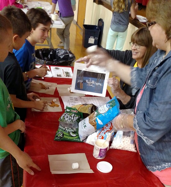 Mary Helen Gensch and Angie Spiecher instruct students how to make the edible International Space Station.
