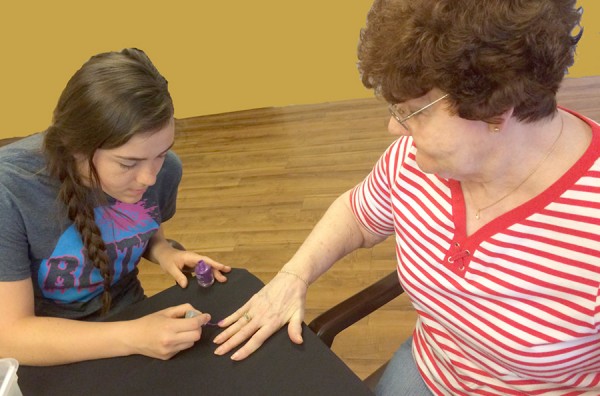 Brooklyn Rummer, of Blitz, paints Silva Deeter's nails. Deeter is a resident of Miller's Merry Manor, Warsaw.