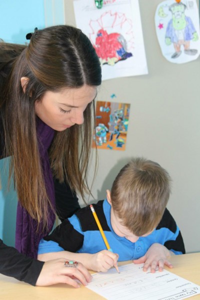 Joe’s Kids therapist, Laura Totedo, assists a child during an occupational therapy session. 
