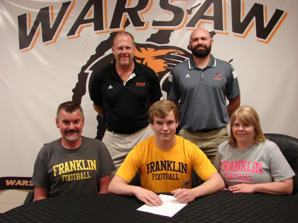 Warsaw's Darren Schaefer will play football at Franklin College. Schaefer is pictured with his parents Eric and Stephanie. In back are WCHS football coach Phil Jensen and WCHS defensive coordinator Kris Hueber (Photo provided)