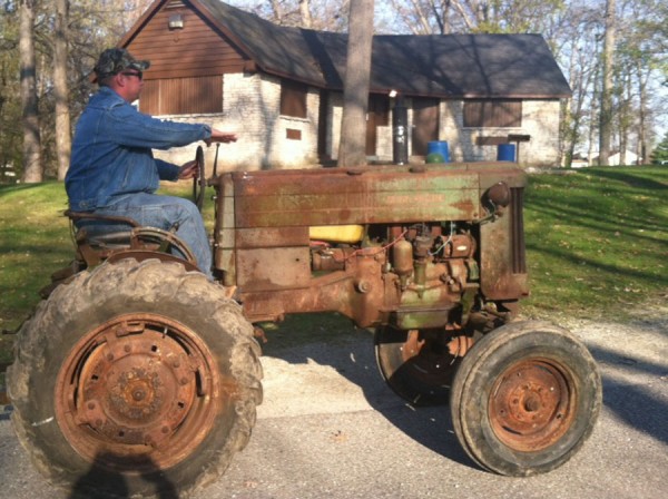 f Warsaw Police officer, Justin, (Tug) Curtis driving his 1953 John Deere 40-S Farm Tractor, (a real classic and rare find) into Lucerne Park for this evenings Mommy Son Adventure hosted by the Warsaw Parks and Recreation Department.