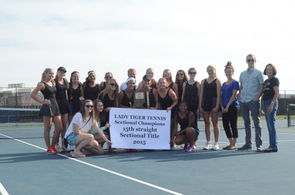 The Warsaw girls tennis team will play in the regional Tuesday. The current team is shown above with past players from the program after winning a 15th straight sectional title on Friday. 