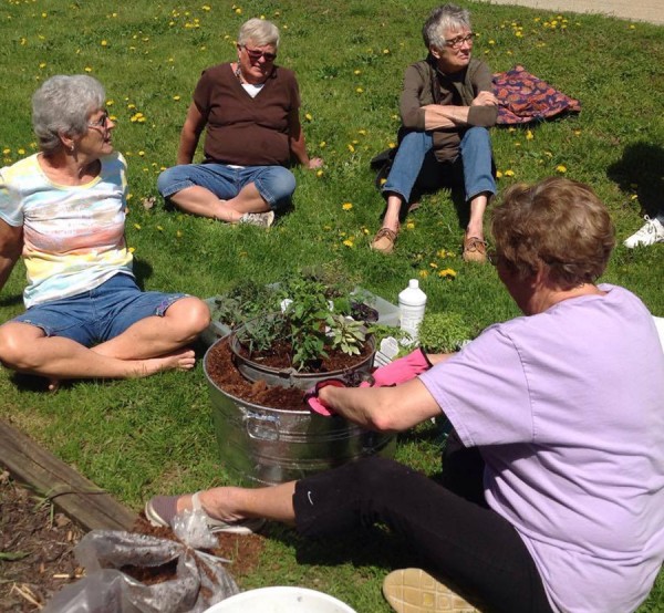 The Herb Lady Janette Stackhouse (far right) demonstrates how to plant and grow herbs in her recent Hooked on Herbs Class while Eleanor Hooker, Marta Wonder, and Marilyn Baney look on.  The next Herb Class will be July 18.