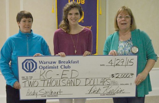 Amy Evans and Brittany Lyons accept a $2,000 donation for KCed from Jennifer Lucht of the Warsaw Breakfast Optimist Club.