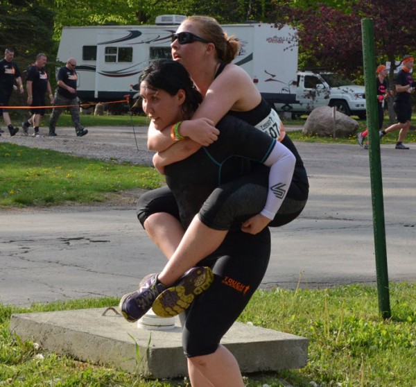 Kari Blackwell carries teammate Tara Meyers through the Warrior Carry obstacle. 