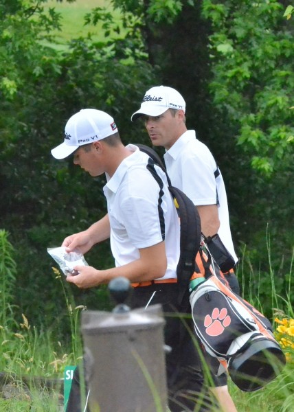 Jonny Hollar walks to his next tee while getting some words of wisdom from Warsaw head coach Ben Barkey.