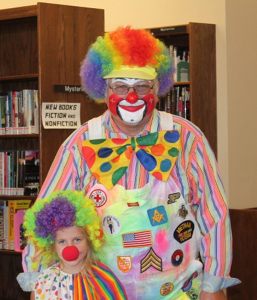Patches the Clown and his sidekick Addie had to pick-up a book at the Syracuse Library this week. Patches is a Vietnam veteran and was seen in the parade on Monday. His costume is a display of important activities in his life. Patches is Ed Leamon and Addie is his granddaughter, Addison Leamon.