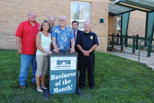 North Webster town officials posed with a sign from the North Webster-Tippecanoe Township Chamber of Commerce honoring the town as the business or organization for the month of July. The sign is on display at town hall. From left, in front, are councilman Lisa Strombeck, council President Jon Sroufe and Police Chief Greg Church. In back are Utilities Manager Mike Noe, park board President Dave Waliczek and Town Attorney Jack Birch. Secretary-Treasurer Betsy Luce and council member Tim Hine were unable to be in the photo. (Photo by Martha Stoelting)