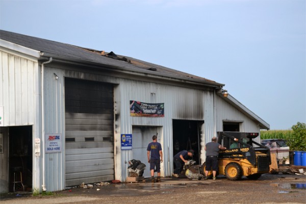 Employees of Price Auto Shop work at cleaning up the damage from the fire early Wednesday morning.