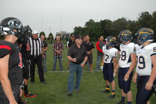 Phil Keiser, NorthWood graduate of 1974 and CEO of Culver's frozen custard, prepares to toss the coin before NorthWood's home game against Fairfield Friday, Aug. 29.