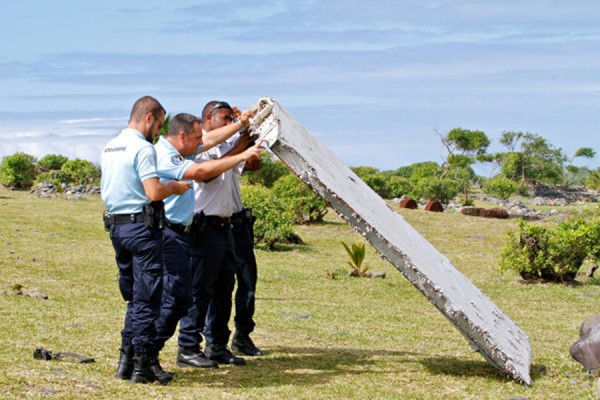 French officers inspected a flaperon, part of a plane's wing, that washed up on a beach on the island of Réunion last week. Credit Lucas Marie/Associated Press