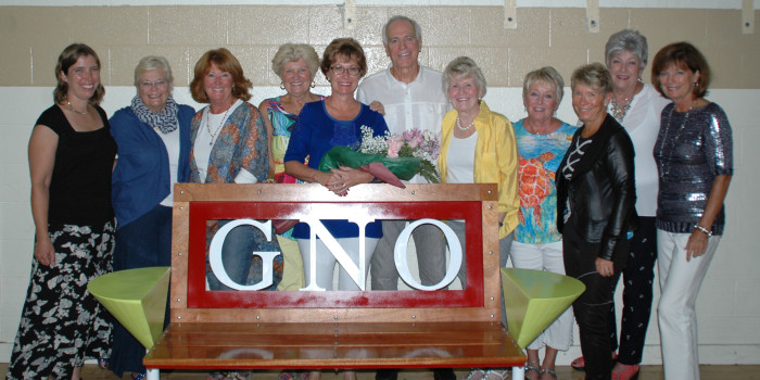 Bill Coon designed this bench to be placed on the trails in honor of GNO, Girls Night Out, a social group involved with many area causes such as Teen Parents Succeeding. From left are Megan McClellan, executive director of Syracuse-Wawasee Trails, Connie Harris, Patsy Lees, Becky Fox, Susan Todd, Bill Coon, Sally Springer, Sara Stearley, Betsy Roby, Barb Coon, Jan Kendall