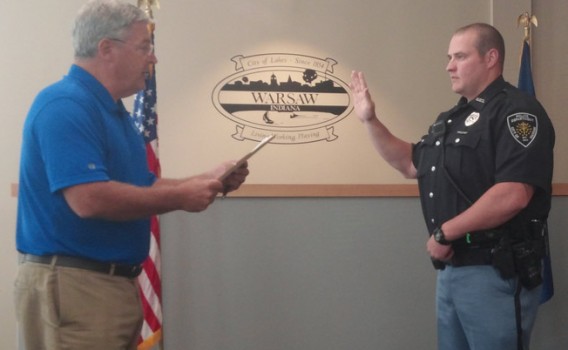 Warsaw Mayor Joe Thallemer gives the oath of office to Warsaw Police Officer Samuel Weaver