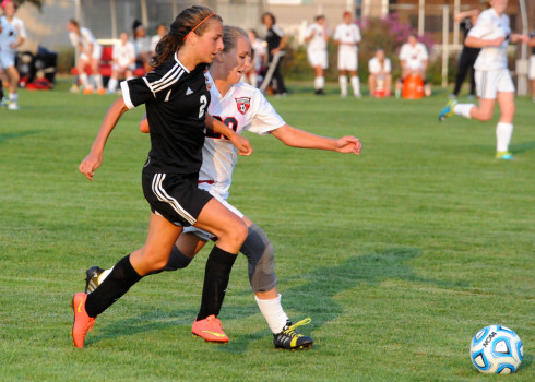 Warsaw's Anna Grill speeds past NorthWood's Sarah Foster.