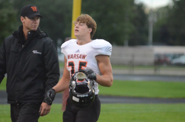 Warsaw running back Will McGarvey leaves the game with trainer Corey Branam after being injured Friday night. 