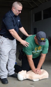 Paramedic Ryan Reed demonstrations with Josh Spangle the proper position for chest compressions.