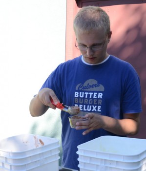 Cory Hilgenberg, an employee at Culver's, scoops out a dip of chocolate custard for guests. Culver's donated the custard for the event and employs clients from the local center.