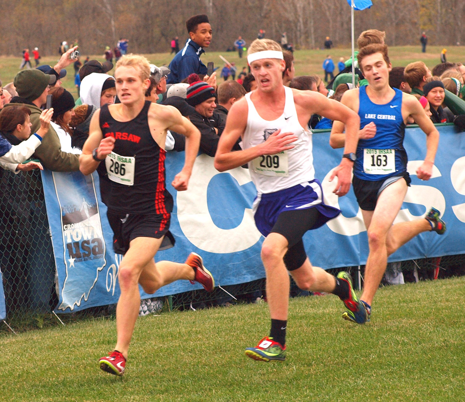 Warsaw's Owen Glogovsky (286) in a dead sprint against New Haven's Deric Laurent (209) as the pair come to the finish line at Saturday's IHSAA state cross country finals in Terre Haute. Glogovsky finished 37th overall in 16:05.3. (Photo by Tim Creason)