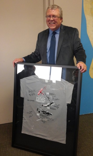 Kurt Carlson, board member of Housing Opportunities of Warsaw, holds a display he made. The display contains a T-shirt signed by all pilots and crews who participated in this years air show.