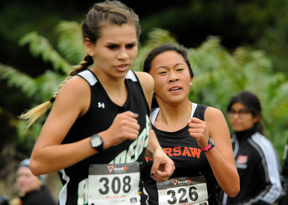 Warsaw's Anna Craig has stepped forward as a force for the girls cross country team. Craig is shown here passing Northridge's Mackenzie Adams at the NLC last weekend. (Photo by Mike Deak)