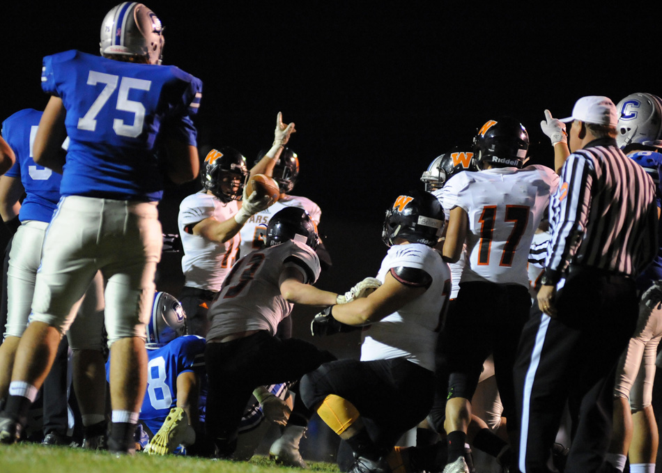 Warsaw's Jacob Foster raises the football after the Tigers recovered a Carroll fumble inside its own five-yard line in the third quarter. Carroll, then, stood tall by holding Warsaw without a score for the second straight possession in what was the turning point of the game.