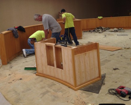 Workers remove old carpet and furniture.