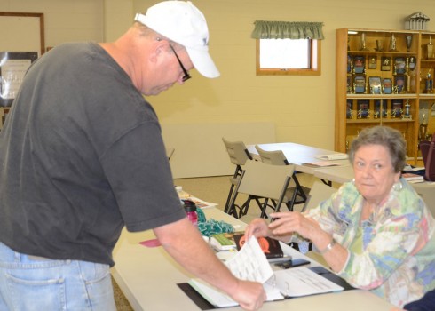 Roger Gall is preparing to cast his vote in the Claypool Town Election after signing in with Theila Banta, poll clerk.
