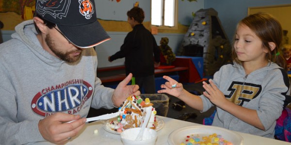 Brentley Lothamer and daughter Victoria Lothamer work together on a gingerbread house masterpiece.