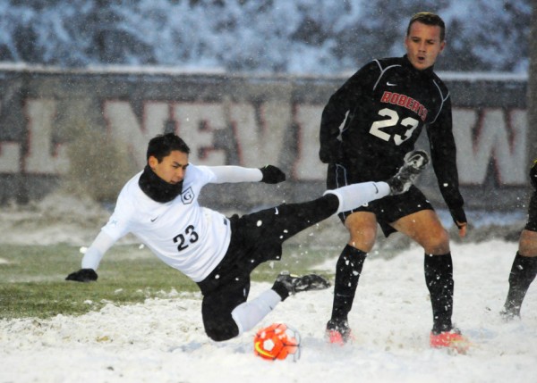 Damon Binkley slips on the surface, defended by Sam Moody.