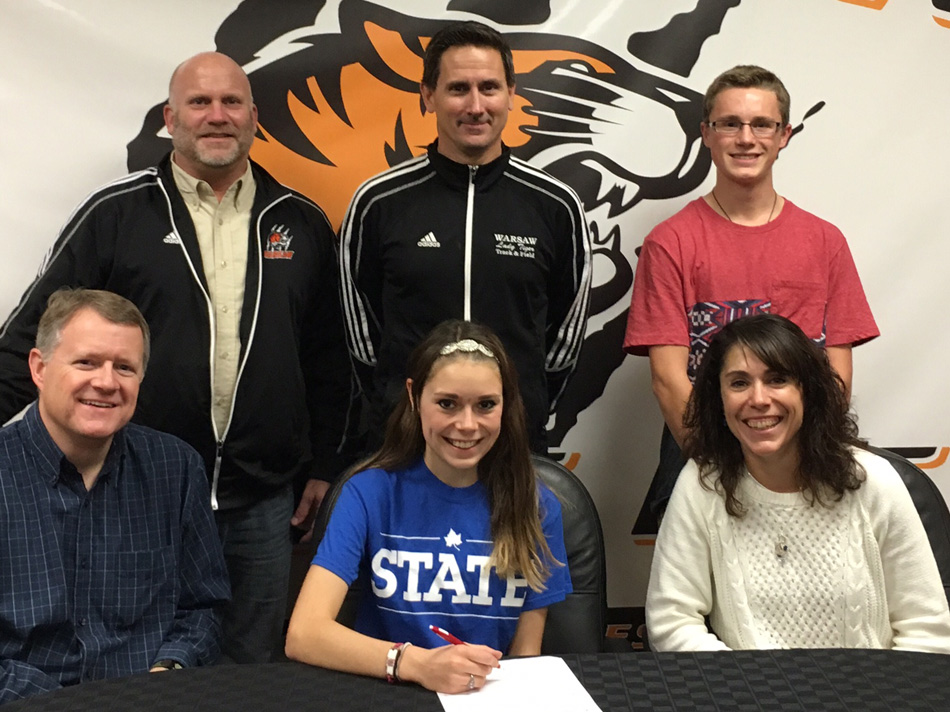 Warsaw Community High School senior Emma Hayward, seated with parents , signed a letter of intent to continue her cross country and track careers at Indiana State University. Standing in the back row are WCHS athletic director Dave Anson, WCHS cross country and track coach Scott Erba, and fff Hayward. (Photo provided)