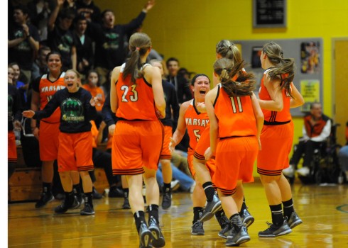 Warsaw's Page Desenberg (facing) celebrates with teammates after Kenzie Welk hit a three at the halftime buzzer.