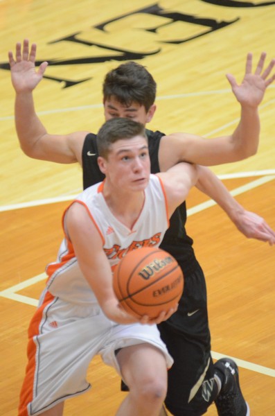 Warsaw star Kyle Mangas scoops one up from the baseline. Mangas helped the undefeated Tigers best Wawasee 79-34 Friday night.