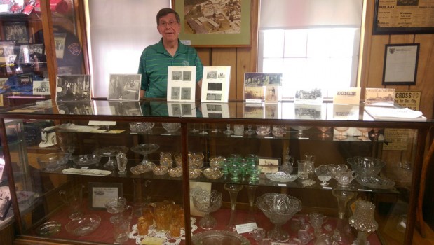 Jerry Long, president of the Gas City Historical Society, shows off colored-glass dinnerware manufactured at the end of the 19th century by the U.S. Glass Factory in Gas City.