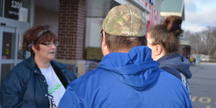 Lanie Scarlett "stalks" two shoppers at Meijer, handing them $100 for their last-minute shopping. (Photos by Amanda McFarland)