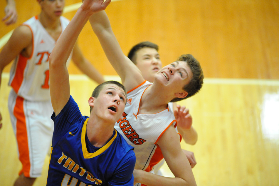Triton's Landon Johnson and Warsaw's Asher Blum tangle working for a rebound.