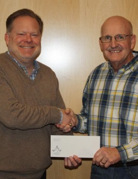 Maple Leaf Farms Co-President Scott Tucker presents a donation check to Leesburg Lions Club President Larry Kammerer. (Photo provided)